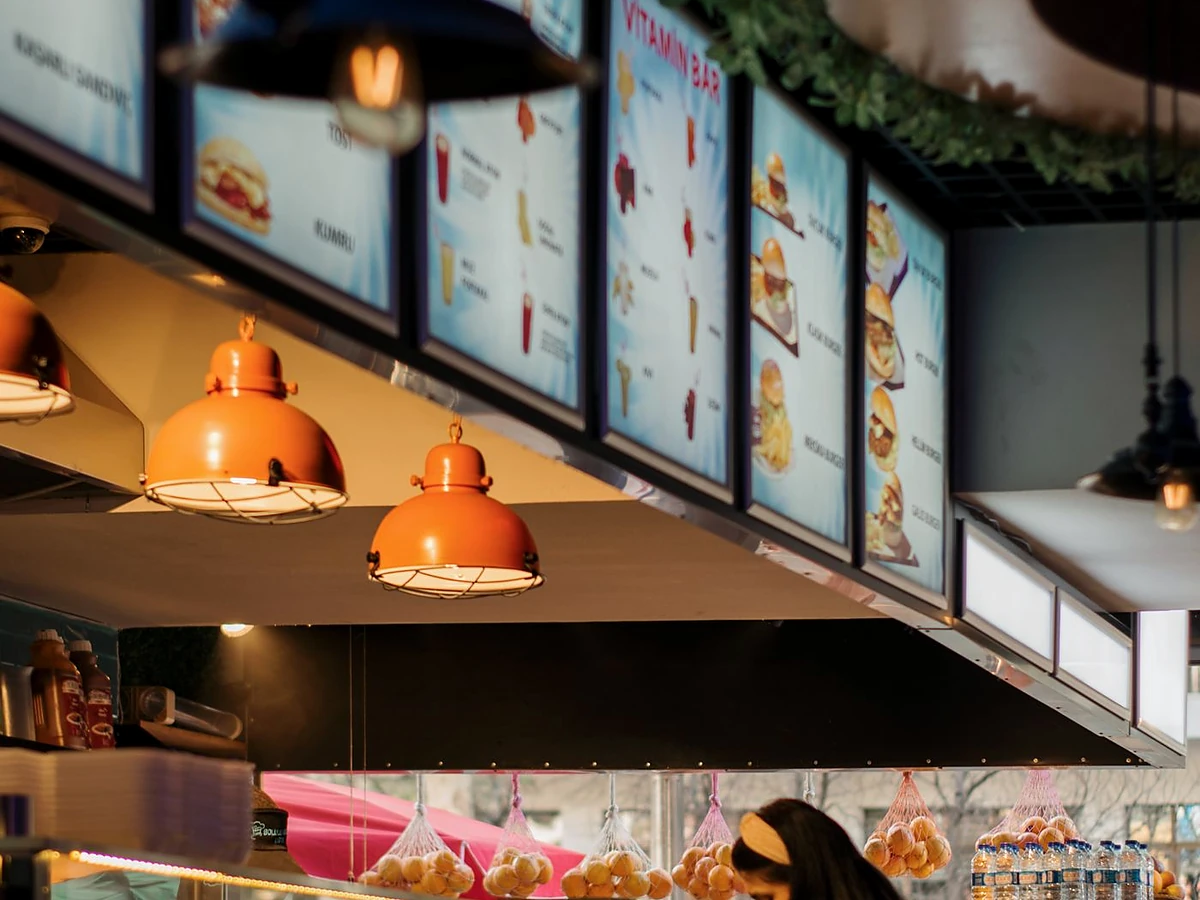 Backlit menu light boxes above a restaurant counter
